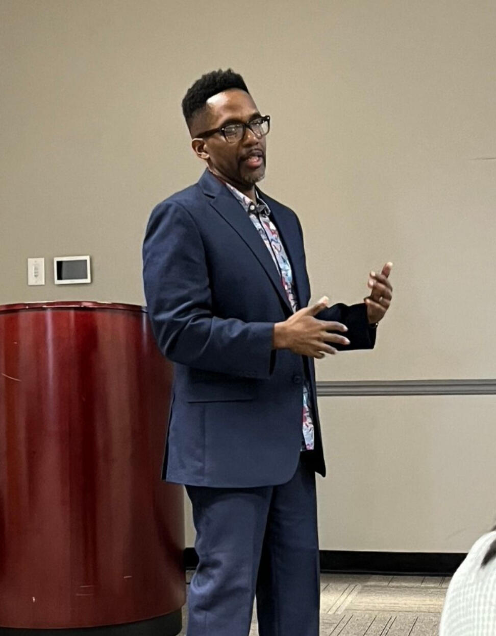 Garrick Gibson — Design Leader & Facilitator Garrick Gibson presenting to an audience, demonstrating his experience as a cross-functional design leader and facilitator in healthcare and benefits organizations